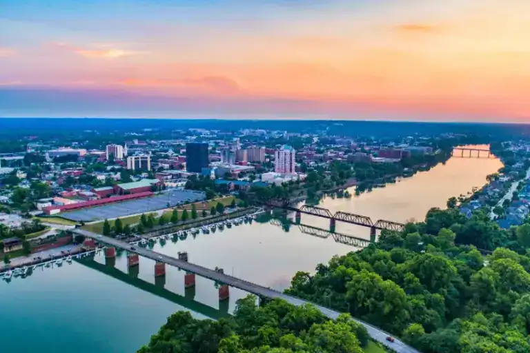 Aerial view of a city with bridges over a river at sunset.
