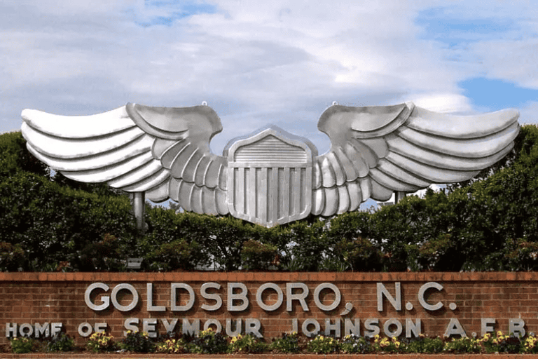 A winged sculpture with a building and gold text in Goldsboro, North Carolina.