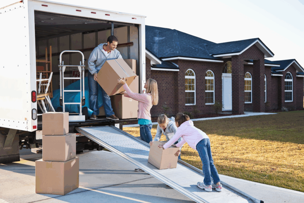 Family unloading moving boxes from a truck during a PCS move.